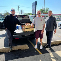 men in front of boxes of food